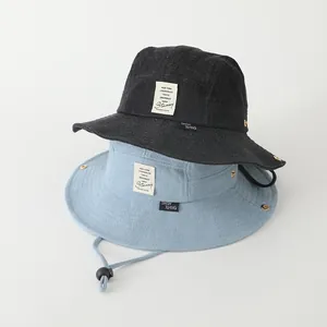 Detalle de sombreros de sol de denim para niños con cordones ajustables en negro y azul