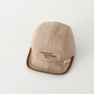 Detail der Baby Baseballkappe mit tomorrow Bestickung und kontrastfarbenem Rand
