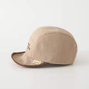 Detail der khakifarbenen Baby-Baseballkappe mit weichem Rand und brauner Stickerei