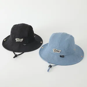 Detalle de gorro pescador infantil de mezclilla con cordón ajustable y ojales metálicos bicolor