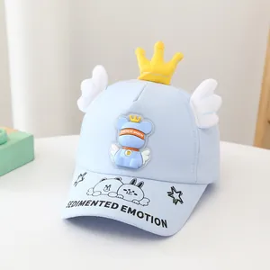 Détail de casquette enfant bleu clair avec couronne jaune et broderie ours dessin