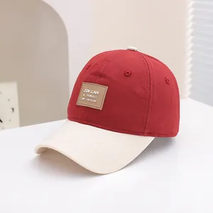Detail van tweekleurige baseballcap met keperkatoen textuur en lederen patch