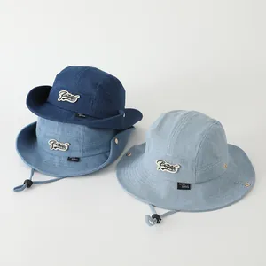 Detalle de sombreros de pescador vaqueros para niños con cordones y broches de presión