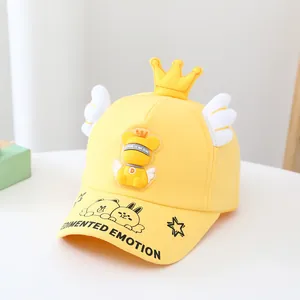 Détail de casquette enfant jaune avec couronne 3D, ailes et logo ours de dessin animé