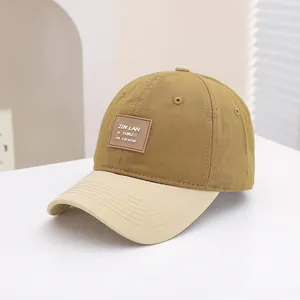 Detail van tweekleurige katoenen baseballcap met lederen patch en fijne stiksels