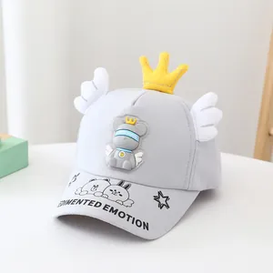 Détail de casquette enfant grise avec couronne jaune 3D et accents d'ailes en peluche