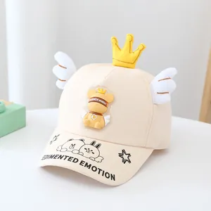 Détail d'une casquette beige pour enfant avec couronne 3D et écusson d'ours mignon