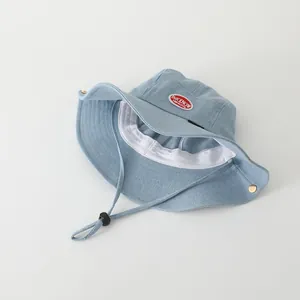 Kids denim sun hat in light blue with red patch and adjustable drawstring strap