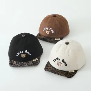 Détail de casquettes bébé avec broderie ours et visières tendance à motif léopard