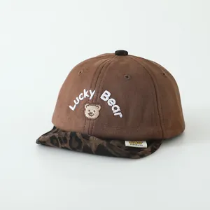 Détail de casquette bébé avec broderie Lucky Bear et visière souple motif léopard