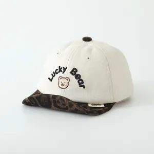 Détail de la casquette bébé avec broderie Lucky Bear et visière souple motif léopard