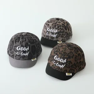 Detailansicht von drei Kinder-Basecaps mit Leopardenmuster und Good Luck Stickerei