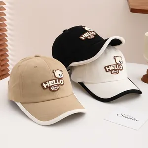 Detail of three cotton baseball caps with bear embroidery and HELLO patch applique