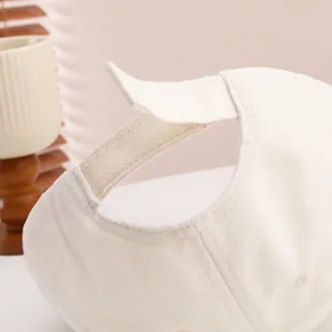 Detail of cream cotton baseball cap with adjustable hook-and-loop strap and neat stitching