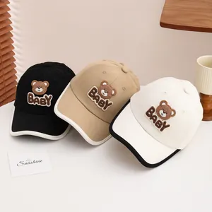 Detailed close-up of colorful kids' baseball hats with bear embroidery and BABY patch