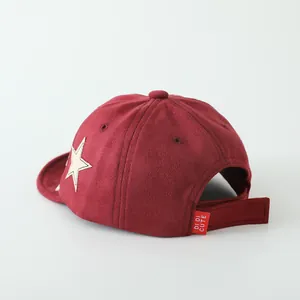 Detail einer weinroten Baby-Baseballkappe aus Wildleder mit Stern-Patch und Verschluss