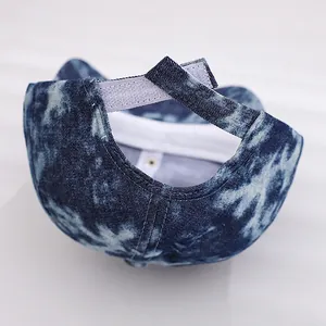 Detail view of adjustable hook and loop strap on blue tie-dye denim kids baseball cap