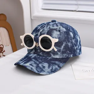 Detail of creative tie-dye denim kids baseball cap with decorative round sunglasses