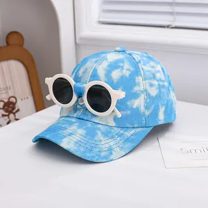 Detail of blue and white tie-dye kids baseball cap with decorative round sunglasses