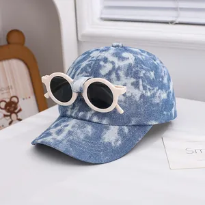Detail of tie-dye kid baseball cap featuring built-in round sunglasses on the crown