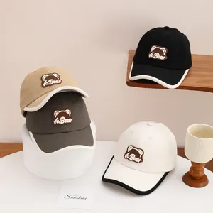Detailed view of kids' bear embroidery baseball caps in multiple colors and textures