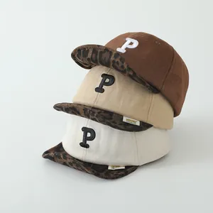 Three children's baseball caps with leopard print brim and embroidered letter P detail