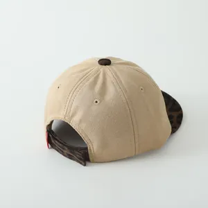 Detail of baby baseball cap featuring khaki suede texture and leopard print brim trim