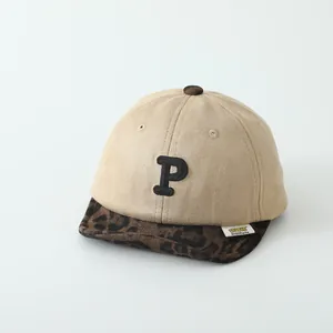 Detail of embroidered P letter and leopard print brim on children baseball cap