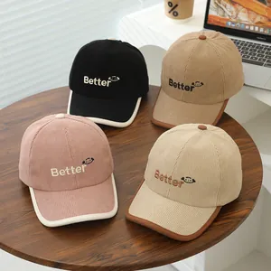 Detail view of corduroy baseball caps with 'Better' embroidery in multiple colors