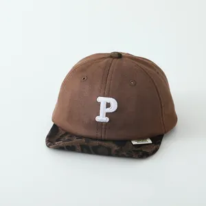 Detailed close-up of brown suede baby baseball cap with leopard print brim and embroidered P