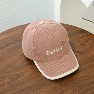 Pink corduroy kids baseball cap with white Better embroidery and cream-colored brim piping