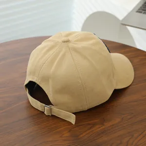 Detail view of khaki cotton baseball cap with adjustable silver buckle and navy embroidery
