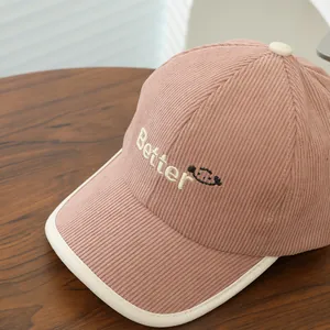 Close-up of pink corduroy texture and 'Better' embroidery on children's baseball cap