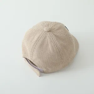 Détail de la casquette beige texturée montrant la fermeture Velcro et la texture du tissu