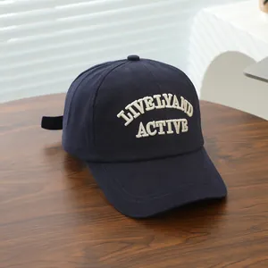 Close-up of navy blue cotton cap with lively and active 3D letter embroidery on wood