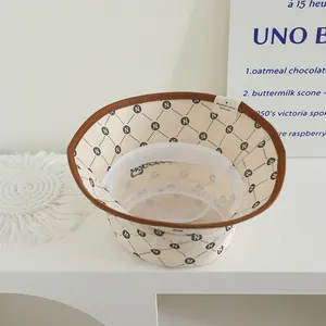 Λεπτομέρεια μπεζ κοτλέ καπέλου με καφέ δερμάτινη επένδυση και καπιτονέ σχέδιο γράμμα Ν