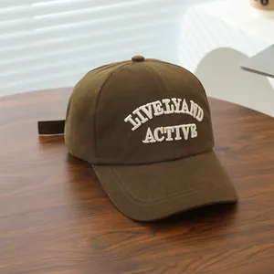 Detail of white 3D embroidery on a dark brown cotton canvas baseball cap for children
