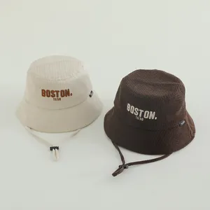 Detail view of corduroy bucket hats with Boston embroidery and adjustable windproof cords