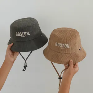 Detail of corduroy bucket hats in grey and brown with Boston embroidery and windproof cord