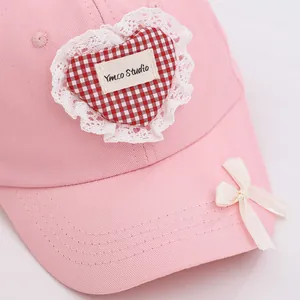 Casquette rose enfant en coton avec écusson cœur en dentelle et nœud en soie crème