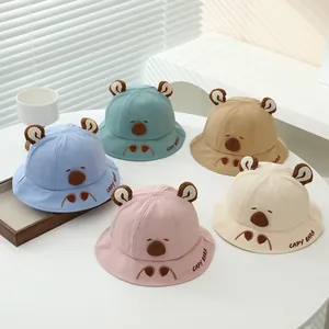 Detail of colorful children's cotton bucket hats with cute ears and Capybara embroidery