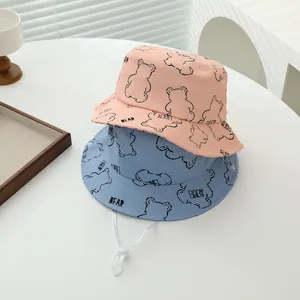 Detalle de sombreros de sol para bebé con estampado de oso en coral y azul con cordón