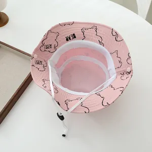 Vista de detalle del sombrero rosa con osos, forro de malla blanca y cordón de ajuste ajustable