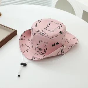 Detalle de gorro de sol rosa para bebé en algodón con dibujos de osos y correa ajustable