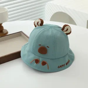 Detail of light blue baby sun hat with cute brown 3D ears and capybara embroidery