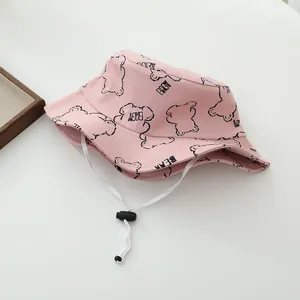 Detalle de gorro de algodón rosa para niños con estampado de oso y correa ajustable