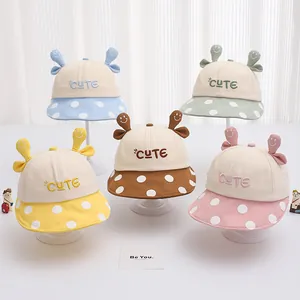 Dettaglio cappelli da sole per bambini in vari colori con orecchie e pois
