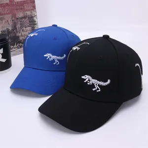Close-up of kids' baseball caps featuring white dinosaur skeleton embroidery in blue and black