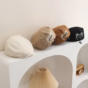 Dettaglio di baschi in cotone per bambini con ricamo di orsetto e coulisse regolabile