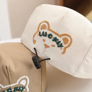 Dettaglio cappellino neonato con orsetto ricamato e chiusura regolabile in cotone